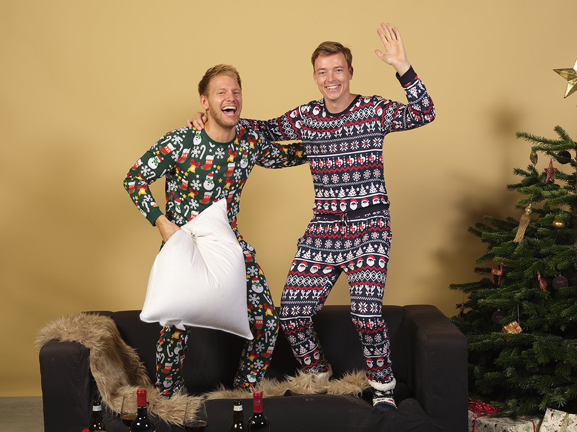 Due uomini che indossano ciascuno il proprio pigiama natalizio.